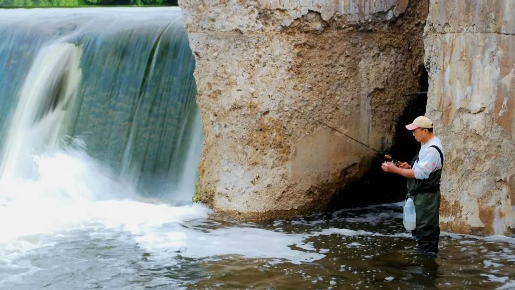 Deux hommes pratiquant la pêche sportive dans la rivière Ste Marie, à Sault St. Marie, en Ontario.