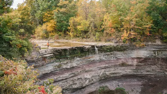 Curved rocky cliff with a small waterfall