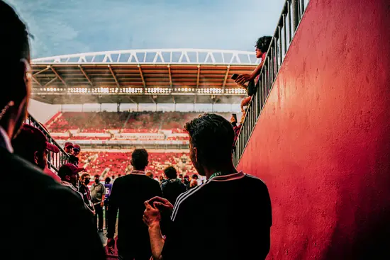 Des spectateurs pénètrent dans un stade bondé pour un match de football.
