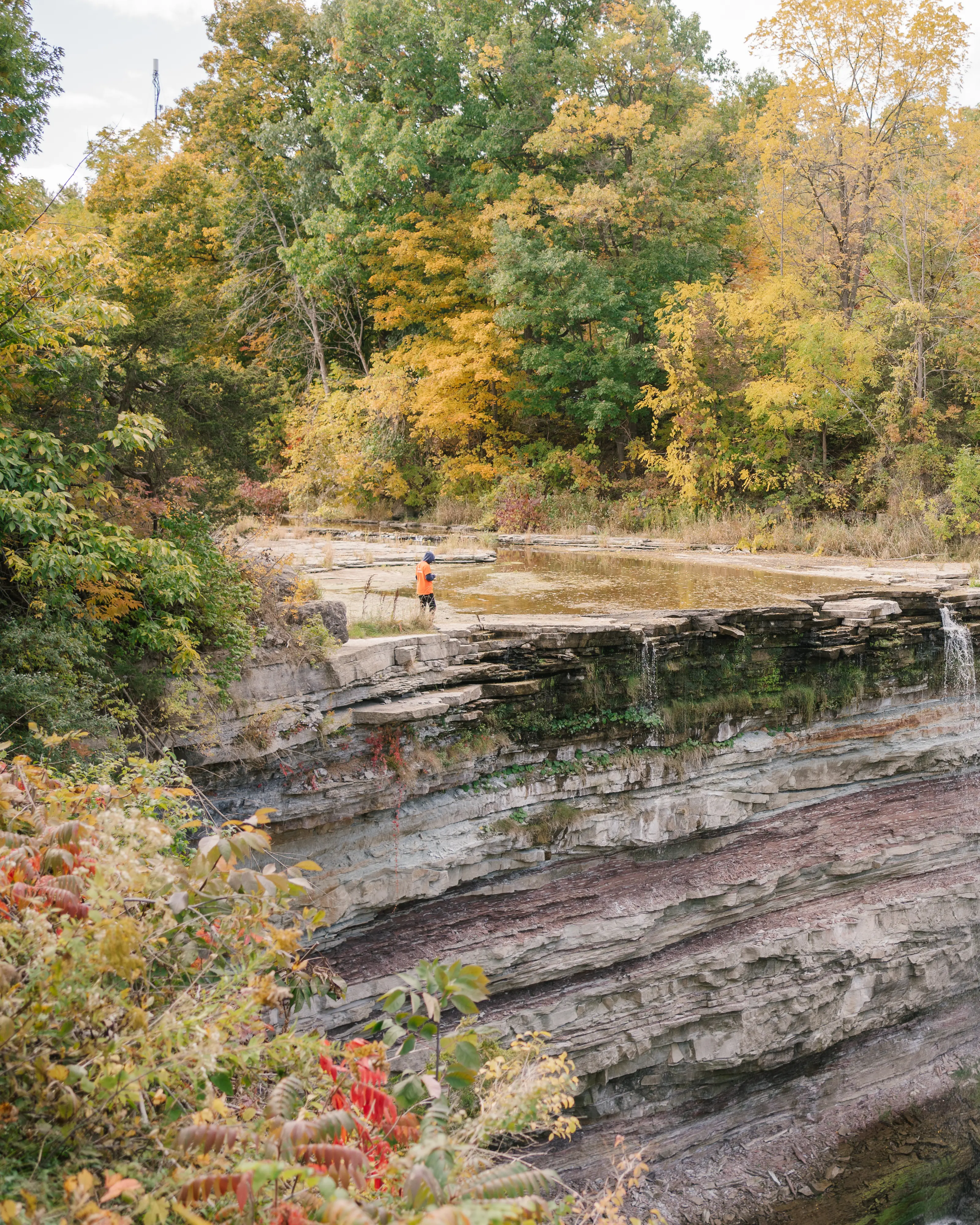 Curved rocky cliff with a small waterfall