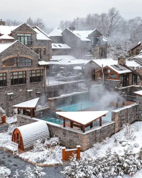 スパリゾートでは、湯気が立ち上る温水屋外プールを、小雪が積もった歴史的な石造りの建物が取り囲んでいます。