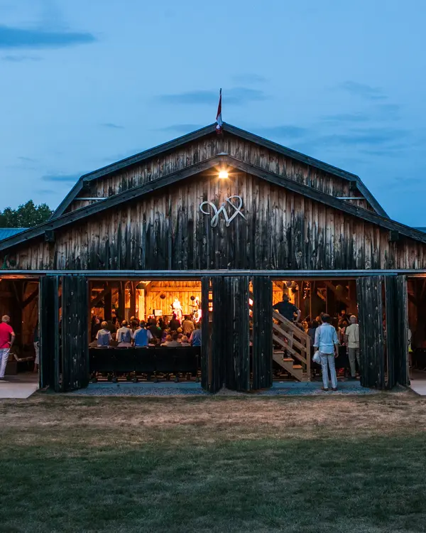 An audience gathers for a musical performance in a converted barn.